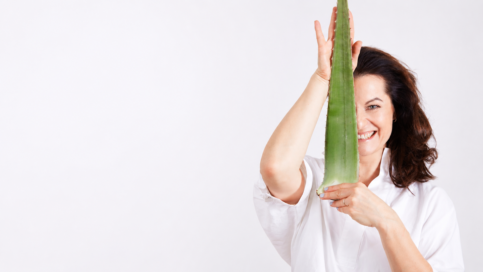 Marika Sokol, Gründerin von Aloe Base, mit einem großen Aloe-Vera-Blatt